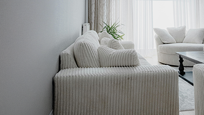 Weiße Polstersofas und Sessel in einem hellen Raum